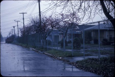 Image of abandoned homes behind a fence